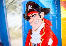 Order a large Indoor pirate bouncer with a slide on the jumping surface, climbing tower and fun obstacles in pirate themed with prints for kids. Buy bouncers online at JB Inflatables UK