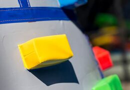 Inflatable covered bouncer in a castle theme with a slide on the jumping surface, climbing tower and fun obstacles for kids. Buy bouncers online at JB Inflatables UK