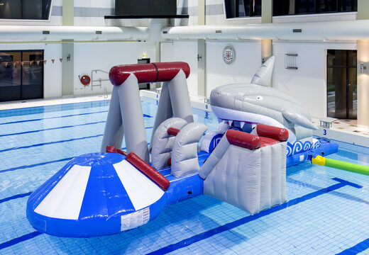 Order an inflatable airtight shark play island with a vine, climbing tower, round slide and obstacles for both young and old. Buy inflatable water attractions online now at JB Inflatables America
